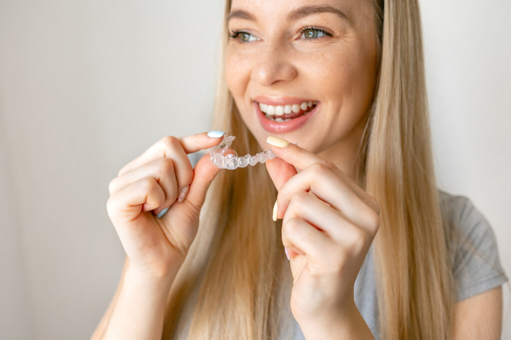 smiling woman putting aligners in